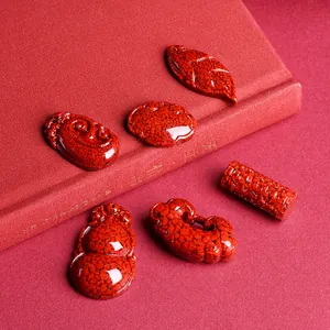 Red cinnabar stone pendants with traditional Chinese shapes on premium red fabric background