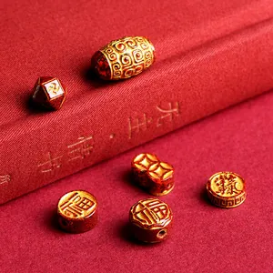 Chinese cinnabar beads set with gold fortune symbols and traditional coin patterns