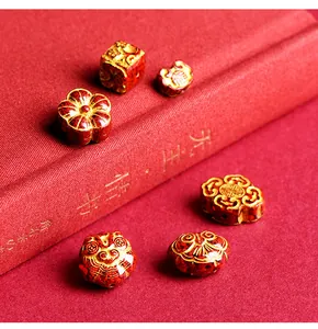 Close-up of red cinnabar ruyi lock beads with golden Fu character and floral patterns