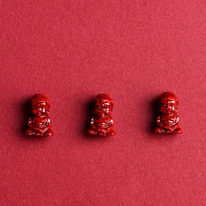 Three red cinnabar Buddha head beads with black stone texture for jewelry making