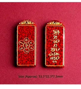 Detailed macro view of red cinnabar pendants with golden Buddhist motifs and carvings