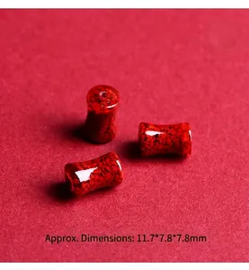 Makroaufnahme von Zinnober-Fassperlen mit polierter Textur und roten Mineralpartikeln