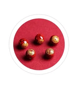 Macro shot of red cinnabar beads with golden Bagua symbols for DIY jewelry making