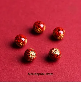 Macro view of 9mm red cinnabar beads with golden pattern and size measurement label