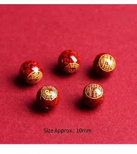 Macro shot of 10mm red cinnabar beads featuring golden Ba Gua and auspicious engravings