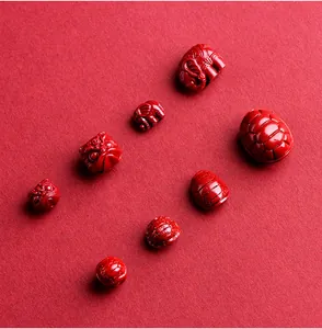 Macro shot of red cinnabar carved beads featuring Chinese auspicious elephant and turtle designs