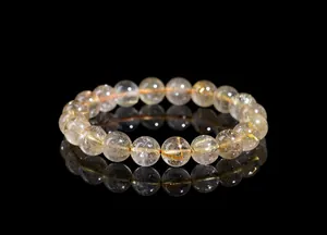 Macro shot of natural golden rutilated quartz beads with visible needle-like inclusions