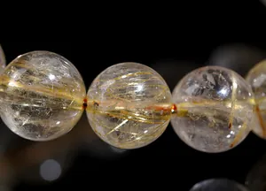 Macro detail of natural golden rutilated quartz beads with visible rutile inclusions