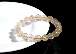 Macro shot of natural rutilated quartz bracelet with golden needle inclusions