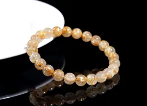 Detail of natural rutilated quartz beaded bracelet with golden rutile inclusions