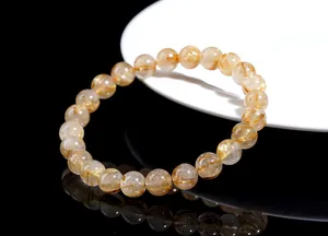 Macro shot of natural rutilated quartz bracelet with golden needle inclusions