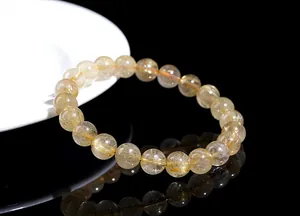 Macro detail of natural golden rutilated quartz beads showing internal needle structures