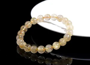 Macro detail of natural golden rutilated quartz beads with shiny needle inclusions
