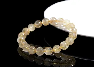 Macro detail of natural rutilated quartz beads with golden hair-like inclusions
