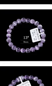 Makroaufnahme von 8mm Natur-Kunzit-Perlen mit Katzenaugeneffekt auf elastischem Armband