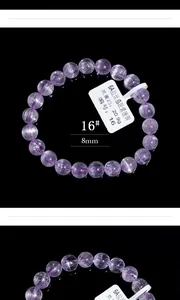Detail eines 8mm lila Kunzit Kristalls Armbands mit Katzenaugeneffekt auf schwarzem Grund