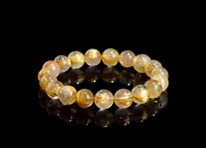 Macro shot of natural golden rutilated quartz bracelet with dense metallic inclusions