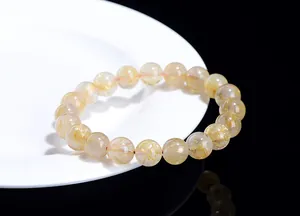 Macro detail of natural golden rutilated quartz crystal beads with needle inclusions