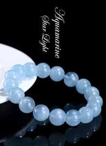 Macro detail of natural star aquamarine beads showing blue glow on black background