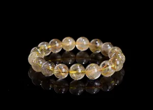 Macro detail of transparent golden rutilated quartz beads with needle inclusions