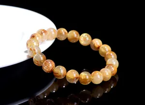Detailed view of natural gold rutilated quartz beaded bracelet with golden hair inclusions