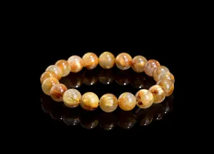 Macro detail of natural golden rutilated quartz bracelet beads with needle-like inclusions