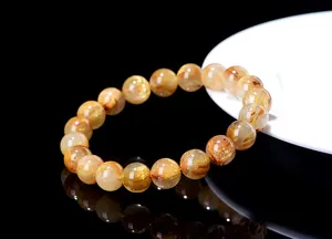 Macro shot of gold rutilated quartz bead bracelet with golden needle-like inclusions