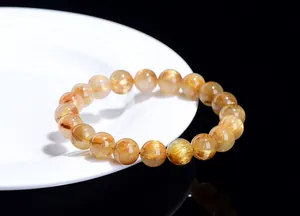 Macro detail of natural golden rutilated quartz beads with shiny metallic needles
