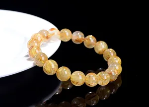 Close-up of golden rutilated quartz crystal bracelet beads showing inner rutile needles