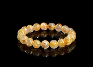 Macro shot of Gold Rutilated Quartz bracelet beads showing golden needle-like inclusions