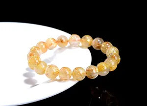 Macro detail of natural golden rutilated quartz crystal beads with needle inclusions