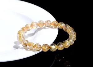 Detailed macro view of golden rutilated quartz beads showing natural mineral inclusions