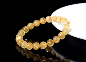 Close-up of golden rutilated quartz beaded bracelet with clear needle-like inclusions