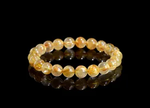 Macro shot of natural golden rutilated quartz beads showing rich metallic inclusions