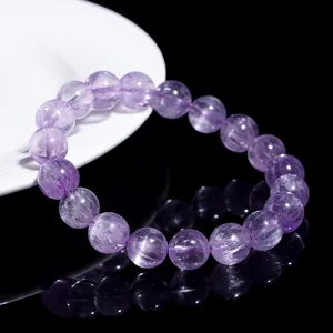 Natürliches Kunzit-Perlenarmband mit Katzenaugeneffekt auf reflektierendem Hintergrund