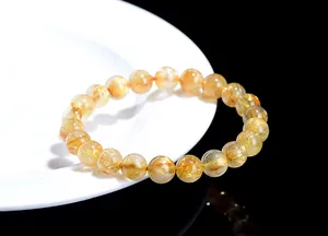 Macro detail of natural golden rutilated quartz crystal beads showing golden needle textures