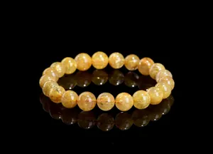Close-up of natural golden rutilated quartz bracelet beads with fine needle inclusions