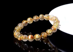 Macro shot of natural gold rutilated quartz beads showing internal needle structures