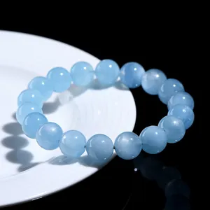 Natural star aquamarine beaded bracelet with translucent blue round beads on a white plate