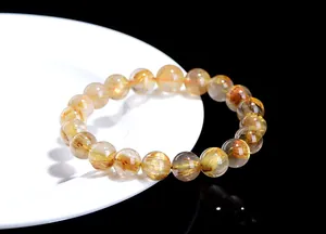 Macro shot of gold rutilated quartz bracelet showing dense golden needle inclusions