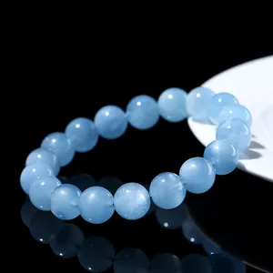 Natural star aquamarine beaded bracelet with translucent blue round gemstones on black surface