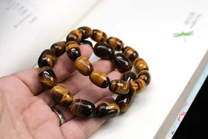 Detailed view of two tiger eye stone barrel bead bracelets with cat eye effect sheen