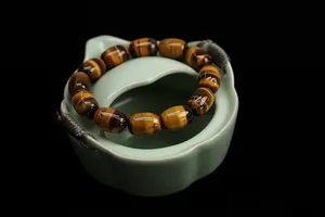 Macro shot of tiger eye stone barrel beads with cat eye effect on celadon base