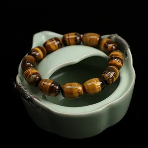 Natural tiger eye stone beaded bracelet with cat eye effect on celadon bowl