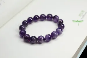 Macro shot of natural purple amethyst beaded bracelet on an open white book background