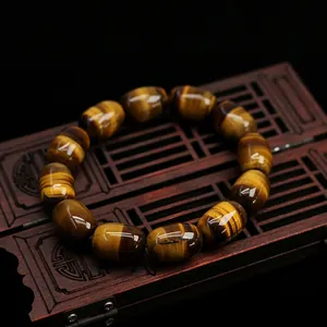 Natural tiger eye stone beaded bracelet with barrel shaped gems on a wooden box