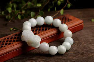 Detailed view of hand-woven natural jade beads bracelet with a carved Pixiu charm