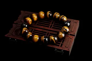 Detailed view of natural tiger eye stone beads bracelet on a classic wooden jewelry stand