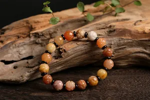 Macro detail of carved lotus beads on natural gemstone bracelet with dark spacers