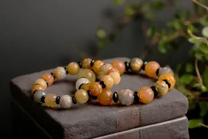 Detailed view of hand-carved lotus jade beads and agate stones in warm natural tones